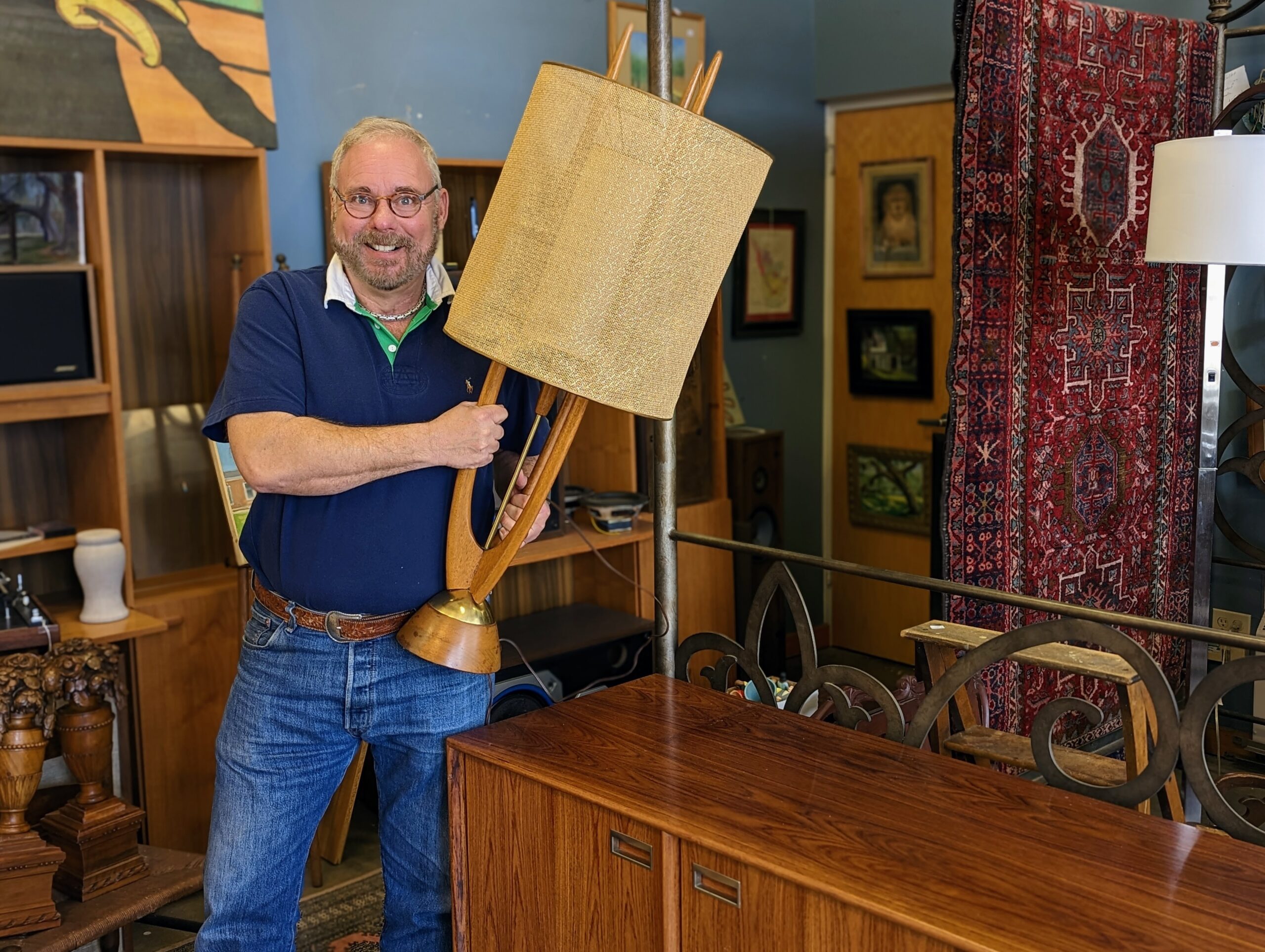 Jeff Scofield, owner of Jeff's Warehouse, holding a Mid-Century modern lamp.